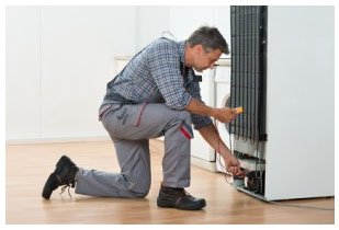 Technician Checking Fridge With Multimeter At Home